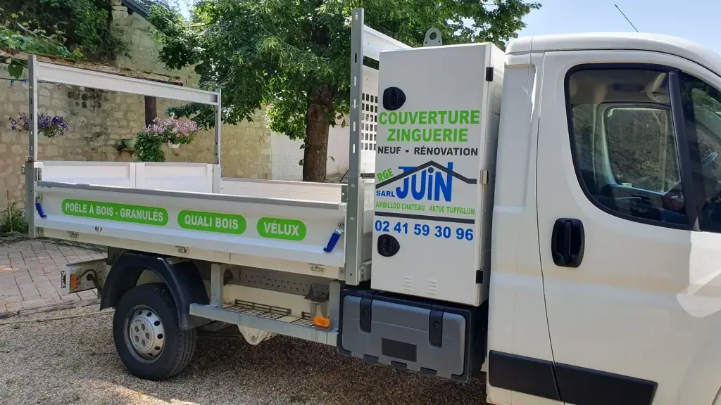 Camion benne blanc de la SARL Juin, couverture zinguerie, marqué de pastilles vertes et du logo bleu