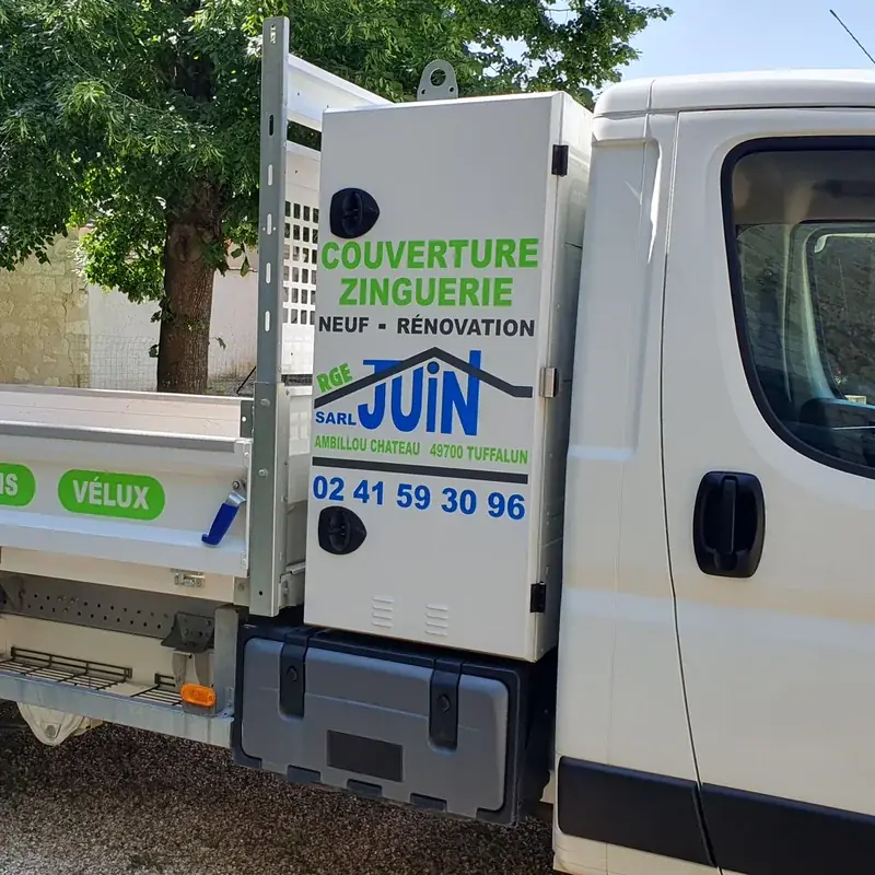 Camion benne blanc de la SARL Juin, couverture zinguerie, marqué de pastilles vertes et du logo bleu