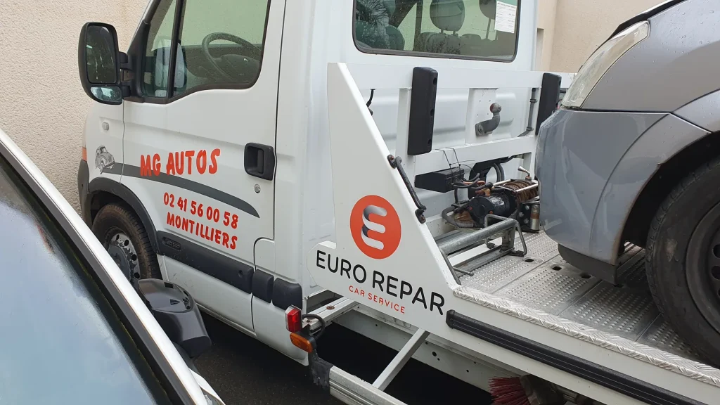 Dépanneuse blanche marquée MG Autos en rouge et logo Eurorepar Car Service sur le plateau