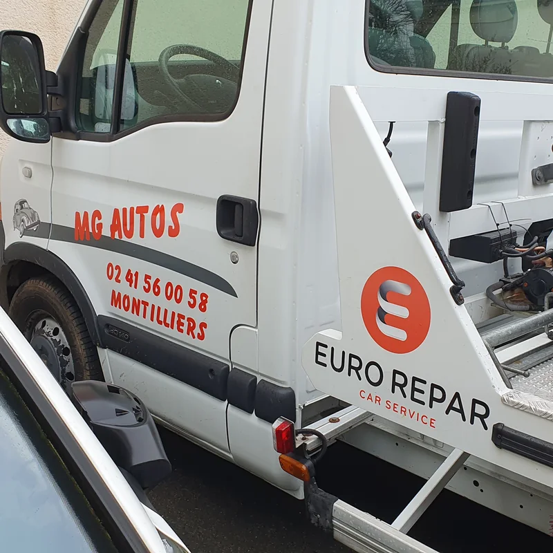 Dépanneuse blanche marquée MG Autos en rouge et logo Eurorepar Car Service sur le plateau