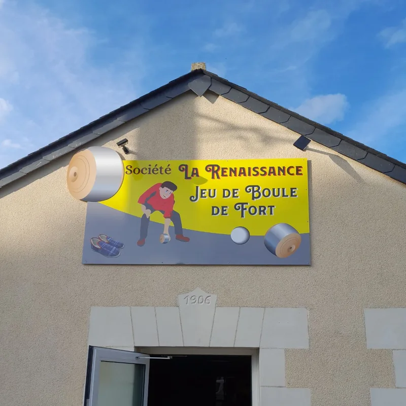 Enseigne jaune de la Société La Renaissance, jeu de boule de fort, au-dessus de la porte d’un bâtiment en tuffeau