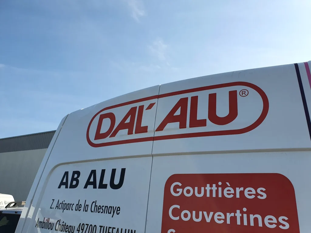 Fourgon blanc AB Alu marqué du logo rouge Dal’Alu et des mentions Gouttières et Couvertines