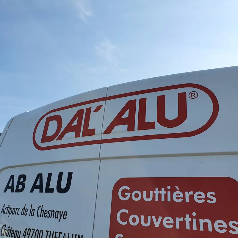 Fourgon blanc AB Alu marqué du logo rouge Dal’Alu et des mentions Gouttières et Couvertines
