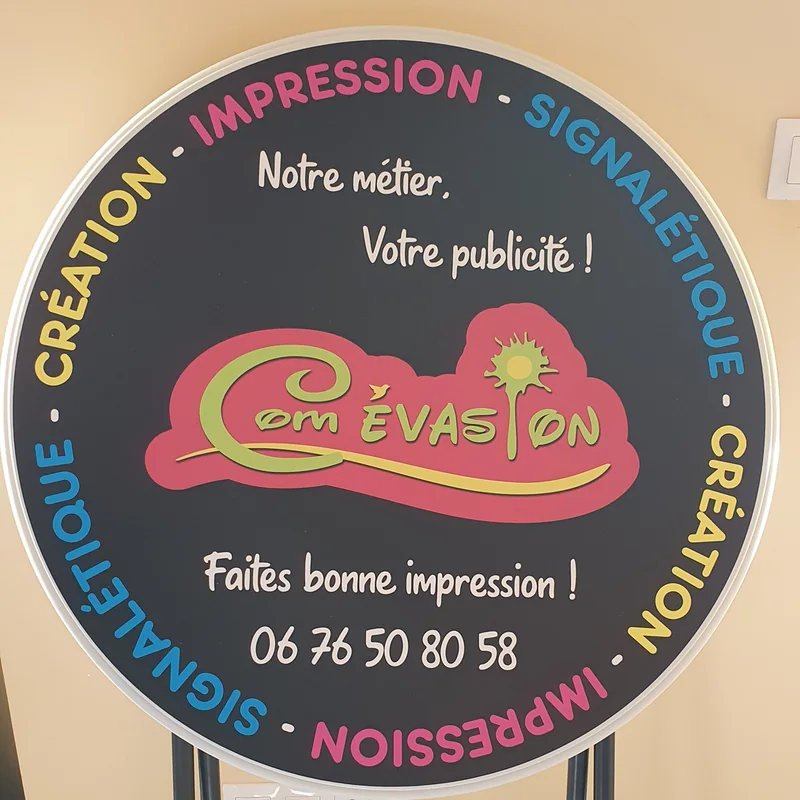 Mange-debout noir au logo Com Évasion, entouré des mots Impression, Signalétique et Création