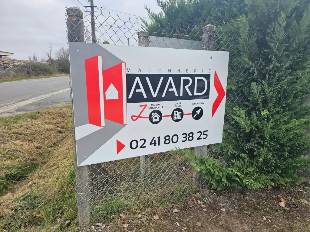 Panneau Maçonnerie Havard fixé sur un grillage en bord de route, logo rouge et numéro de téléphone