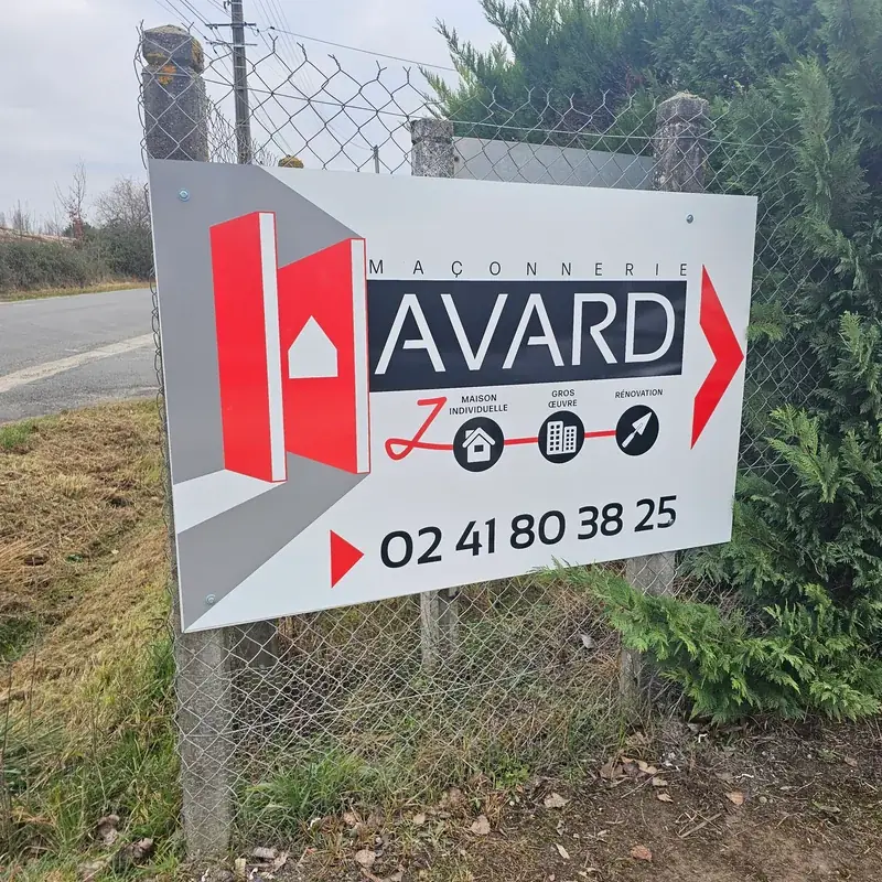 Panneau Maçonnerie Havard fixé sur un grillage en bord de route, logo rouge et numéro de téléphone