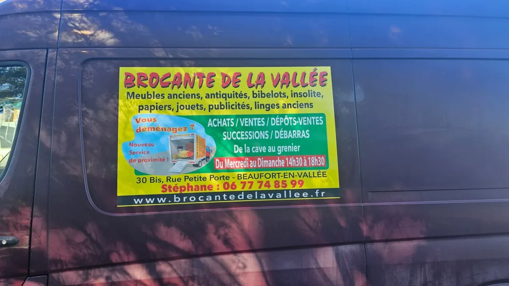 Adhésif publicitaire de la Brocante de la Vallée posé sur le flanc d’un fourgon bordeaux