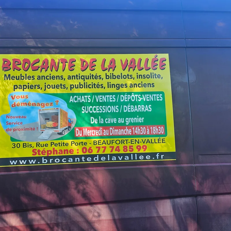 Adhésif publicitaire de la Brocante de la Vallée posé sur le flanc d’un fourgon bordeaux