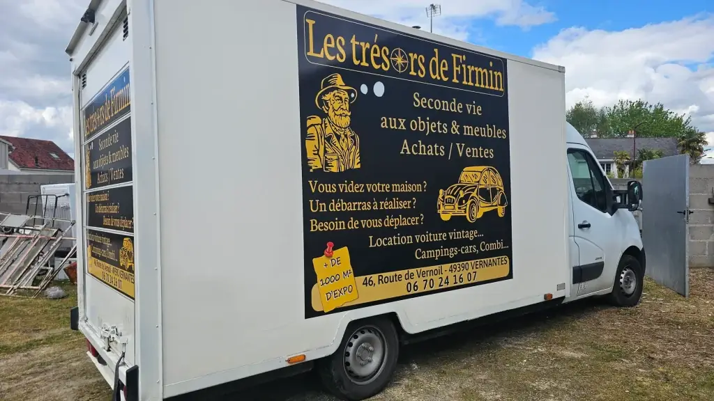 Camion blanc floqué « Les trésors de Firmin, seconde vie aux objets et meubles » sur fond noir et or