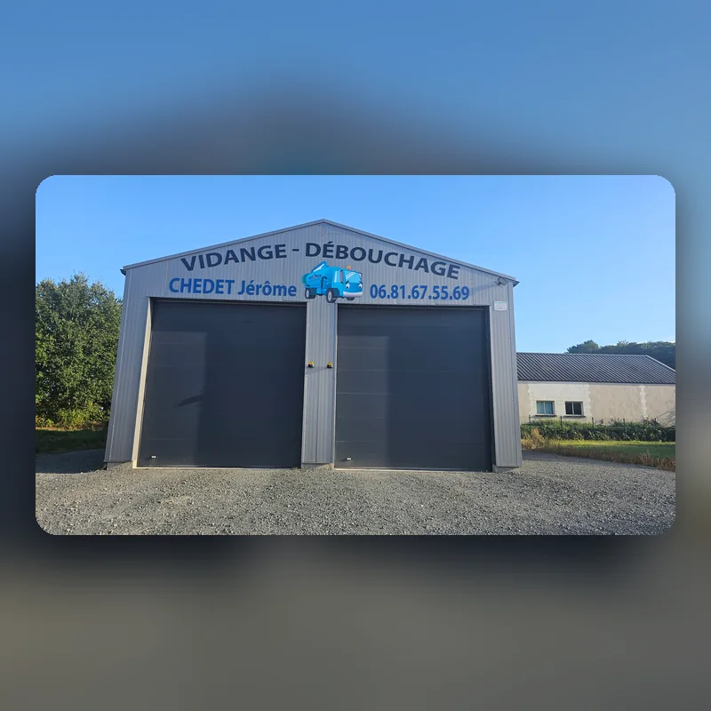 Bâtiment en bardage gris avec l’enseigne « Vidange, débouchage, Chedet Jérôme » et son camion découpé