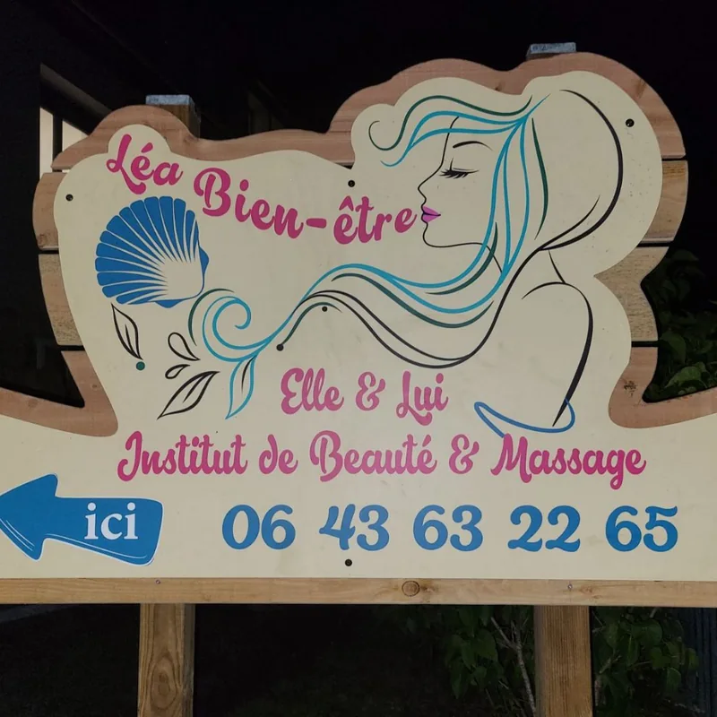 Panneau découpé à la forme du logo Léa Bien-être, avec une flèche « ici » et le numéro, sur poteaux de bois